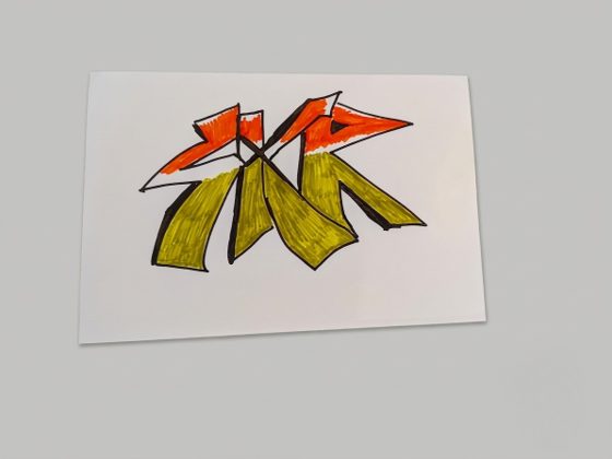 Graffiti-style SKR tag hand-drawn in orange and yellow marker on white card